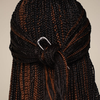 Close-up of braided hair with the kitsch silver mini metal french clip on a beige background