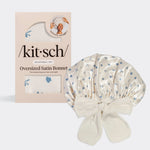 KITSCH Pearlized Cream & Coastal Blue Print Oversized Satin Bonnet — hero product shot with /kit·sch/ packaging — Adjustable, double-layered satin with coastal-inspired dainty bows & seashells print — For preserving your hair overnight