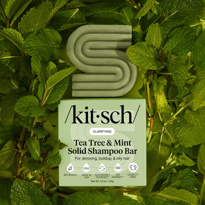 KITSCH Tea Tree & Mint Clarifying Solid Shampoo Bar and packaging box displayed on lush fresh mint leaf background — labeled CLARIFYING, For oiliness, buildup, & oily hair — bottle-free clarifying shampoo bar for oily, buildup-prone hair and scalp