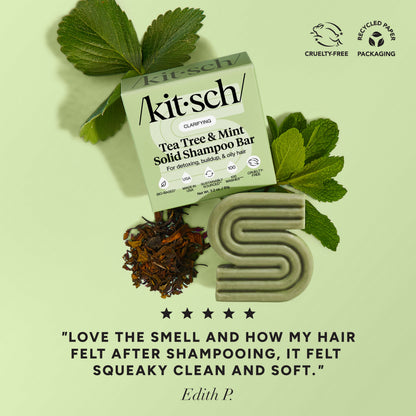 5-star customer review flat-lay for KITSCH Tea Tree & Mint Clarifying Solid Shampoo Bar on light green background styled with fresh mint leaves and tea leaves — Edith P.: "LOVE THE SMELL AND HOW MY HAIR FELT AFTER SHAMPOOING, IT FELT SQUEAKY CLEAN AND SOFT." — Cruelty-Free, Recyclable Paper Packaging